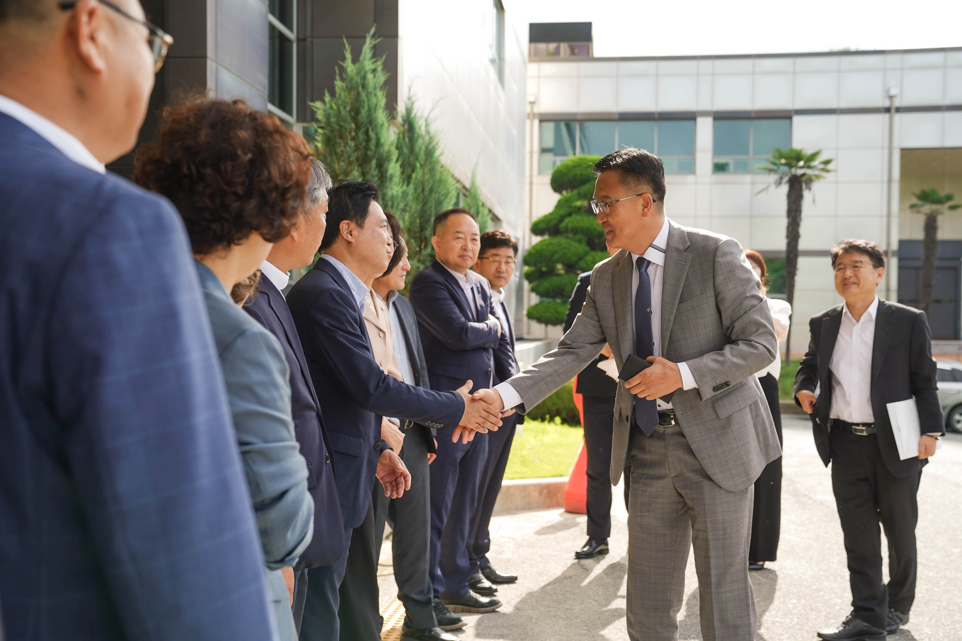 목포시청 건물 앞에서 조석훈 부시장이 한 줄로 서서 기다리던 직원들과 차례대로 악수를 나누며 인사하는 모습.
