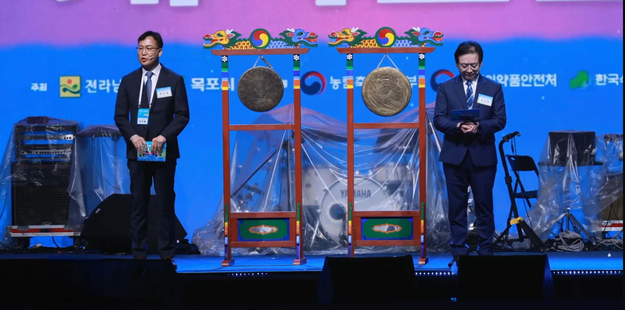 행사 무대 전경. 조석훈 목포시장 권한대행과 김영록 전라남도지사가 나란히 서 있음. 중앙에는 개막 퍼포먼스를 위한 두 개의 징이 배치되어 있고, 배경에는 전라남도, 목포시, 농림축산식품부, 식품의약품안전처 등 후원 및 주최 기관 로고가 보임.